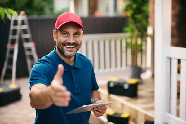 Handwerker vor Ort mit Unterlagen in der Hand
